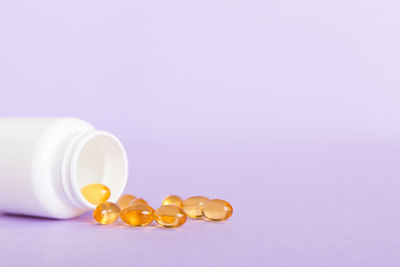 Pills spilling from bottle against white background