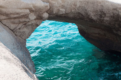 Rock formation in sea against sky