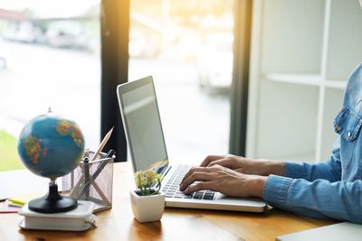 Close-up of man using laptop on table