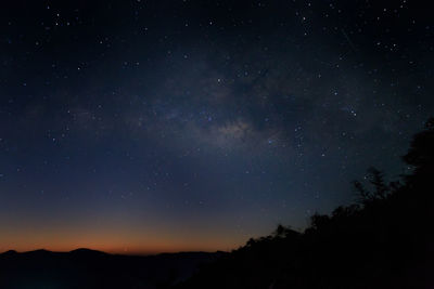 Low angle view of silhouette mountain against star field