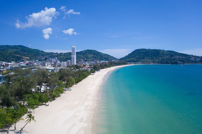 Scenic view of sea and buildings against blue sky