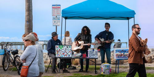 People standing at table against the sky