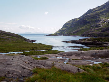 Scenic view of sea and mountains against sky