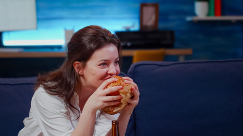 Close-up of young woman eating food at home