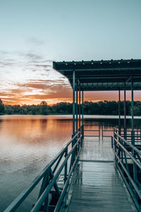 Bridge over lake against sky during sunrise 