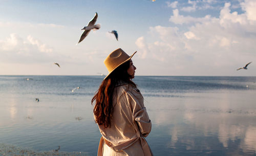 Back view of woman on pier with sea birds