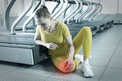 Portrait of young woman sitting on escalator