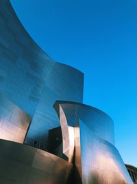 Low angle view of modern building against blue sky