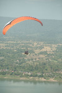 View of person paragliding over water