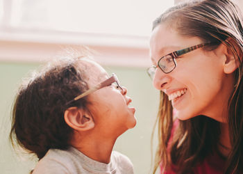 Mother embracing with cute girl at home