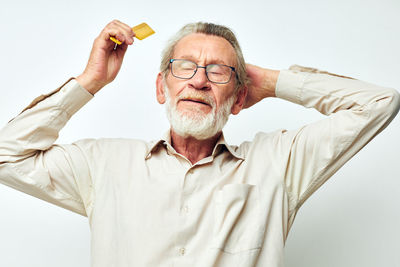 Portrait of young man standing against white background