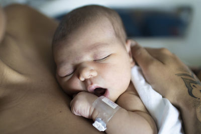 Close-up of newborn sleeping in the hospital with mum