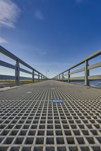 Surface level of bridge against blue sky