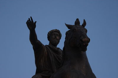 Low angle view of statues against clear sky