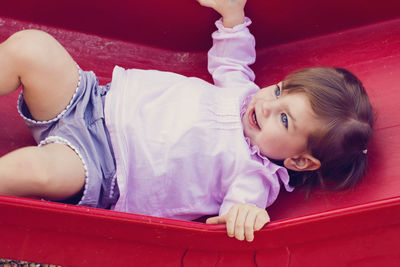 High angle view of cute girl lying on slide