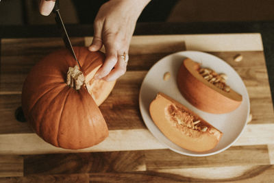 Cropped hand of woman cutting knife