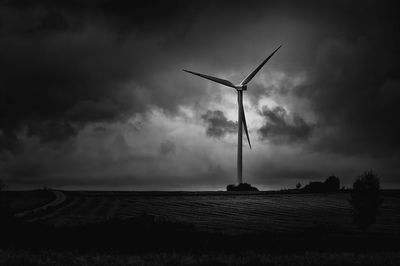 Windmills on field against sky