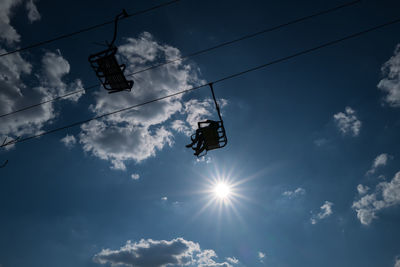 Low angle view of overhead cable car against sky