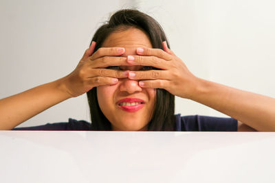 Portrait of a smiling woman covering face