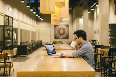 Man using mobile phone while sitting on table