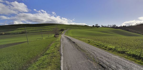 Scenic view of road by land against sky