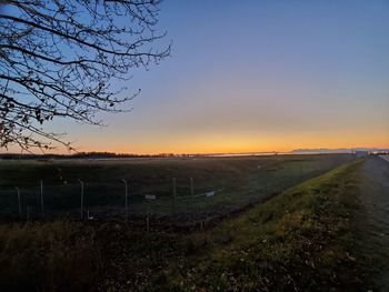 Scenic view of field against clear sky during sunset