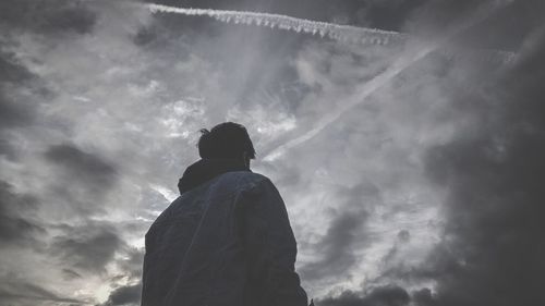 Low angle view of silhouette man standing against sky