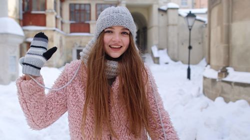 Portrait of young woman holding coffee cup while standing outdoors