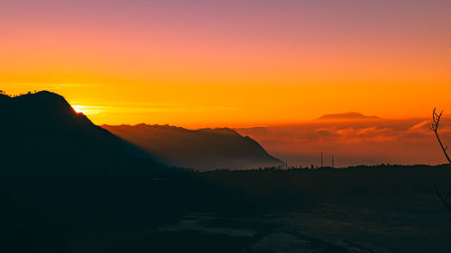 Scenic view of silhouette mountains against romantic sky at sunset