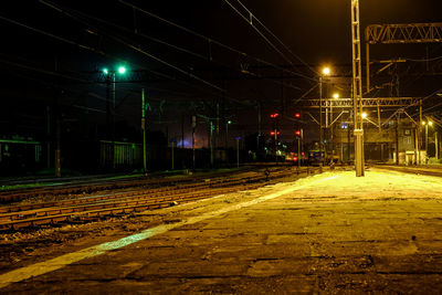 Illuminated railroad station platform at night
