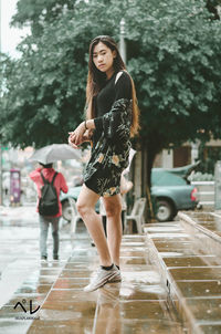 Full length of woman on wet street in city