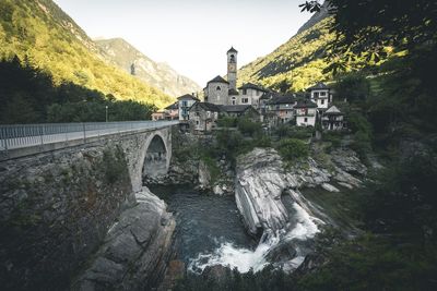 Bridge over river by mountain against sky