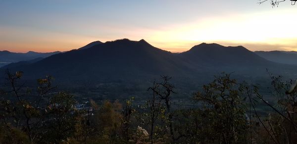 Scenic view of silhouette mountains against sky at sunset
