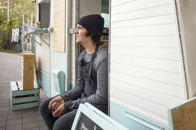 Thoughtful male owner sitting in food truck on street