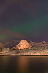 Scenic view of snowcapped mountains against sky at night