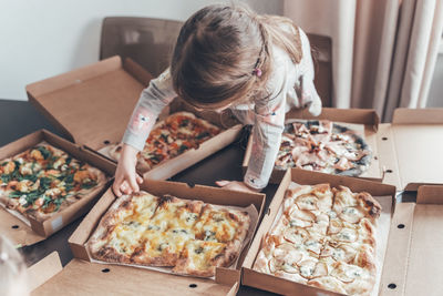 Cute girl eating pizza at home