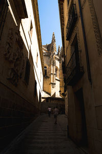 People walking on footpath amidst buildings in city