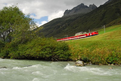 Scenic view of river and mountains against sky