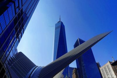 Low angle view of modern buildings against clear blue sky