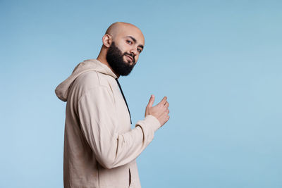 Low angle view of man against blue background