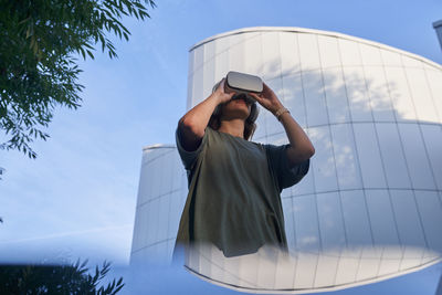 Rear view of woman photographing against sky