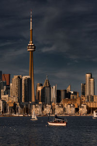 Sailboats in city against sky