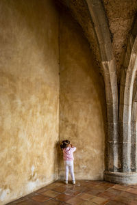 Full length of woman standing against building