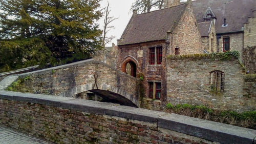 Old building by trees against wall