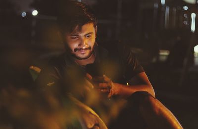 Portrait of young man sitting in the dark