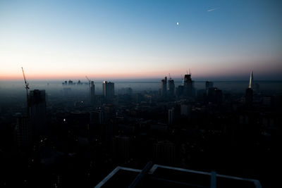 Aerial view of buildings in city during sunset