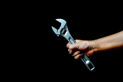 Close-up of hand holding hands against black background