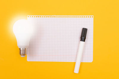 High angle view of pen on table against yellow background