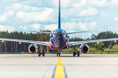 Airplane on runway against sky