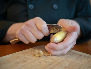 Close-up of man holding ice cream on table